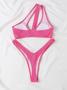 Détail du bikini côtelé rose rouge avec découpe asymétrique et anneaux dorés décoratifs
