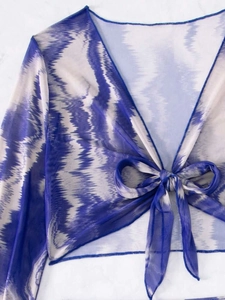 Détail du haut court en maille tie-dye bleu et blanc avec lien noué sur le devant