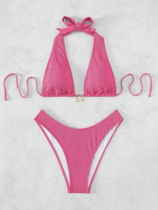 Flat lay of pink ribbed halter bikini set with golden shell and starfish charms detail
