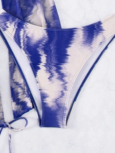 Détails à plat du bas de bikini tie-dye bleu et blanc avec des liens sur les côtés
