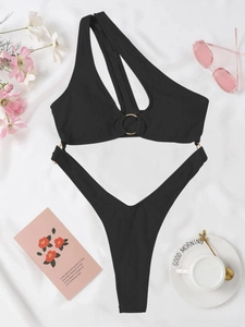 Détail du maillot de bain noir à une épaule, texture côtelée et anneau doré