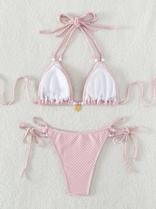 Ensemble bikini rose licou avec perles et pendentif cœur sur fond en fausse fourrure
