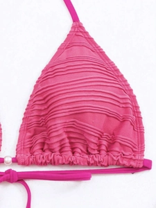 Detail of rose red pleated bikini top featuring elegant white faux pearl accents