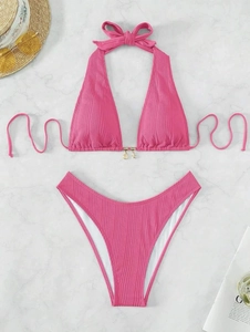 Detailed fuchsia ribbed bikini set with starfish shell charms on a marble background
