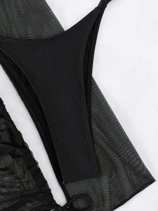 Détail du bas de bikini noir avec empiècements en résille transparente et tissu extensible