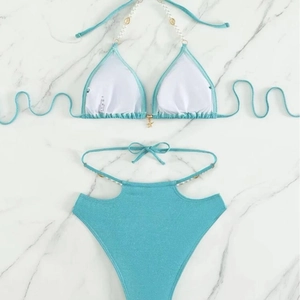 Bikini bleu scintillant avec perles et breloques coquillages sur marbre