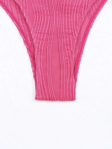 Detail of pink bikini bottoms featuring ribbed texture and fine mesh stitching accents