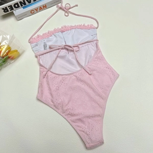 Detailed close-up of pink lace bikini with halter neck straps and white size label