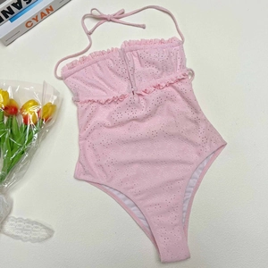 Detail of pink eyelet embroidery one-piece swimsuit with ruffle trim and halter ties