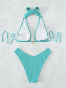 Detail of lake blue ribbed bikini with halter neck bow and gold shell pendants