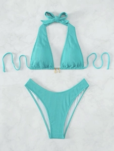 Detail of teal ribbed bikini fabric with decorative metal shell and starfish charms