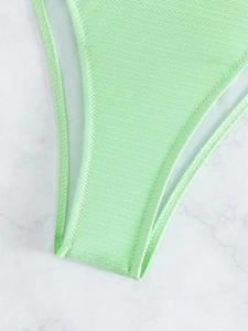 Dettaglio del tessuto bikini verde menta con motivi jacquard a zigzag e cuciture fini