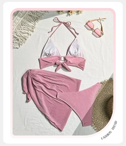 Détail d'un bikini rose scintillant trois pièces avec jupe de plage et anneau métallique