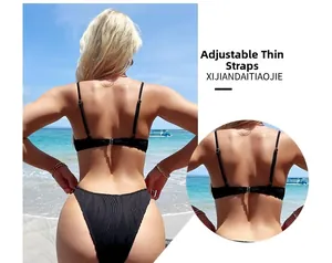 Detail of adjustable thin shoulder straps and vertical ribbed texture on a black bikini back