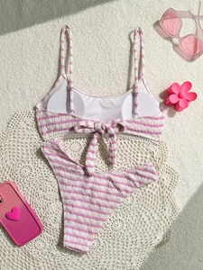 Detailed flat lay of pink and white striped bikini with ribbed fabric and bow detail