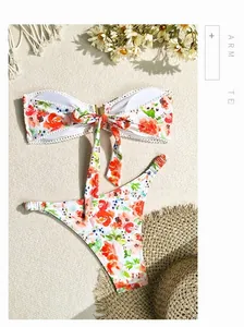 Vue à plat d'un bikini floral avec bords au crochet et accessoires de plage sur tissu