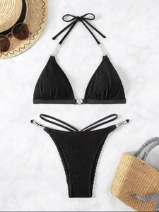 Black halter bikini set with bubble texture and silver chain links on marble background