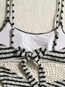 Striped bikini top with adjustable straps and decorative back bow on soft texture