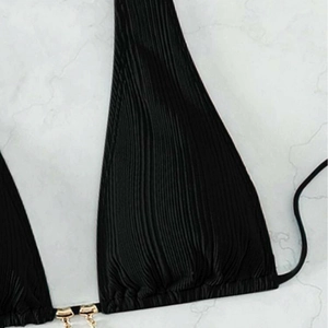 Chic black halter bikini top with ribbed texture and gold metallic hardware detail