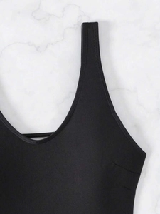 Detail of black one-piece swimsuit featuring a deep neckline and premium double stitching