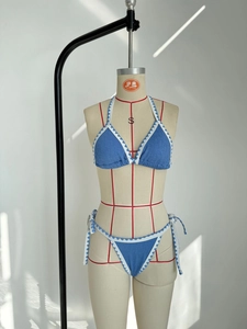 Detailed view of blue two-piece bikini with scalloped trim and textured fabric