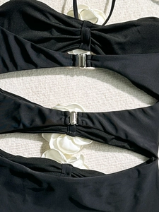 Chic black one-piece swimsuit with metallic buckle and 3D white floral details