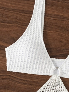 Detail of white waffle knit bikini top featuring a silver metal ring and halter neckline