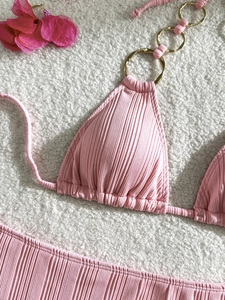 Close-up of pink ribbed bikini top with golden metal ring detail and halter design