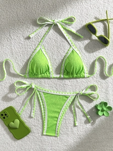 Detail of neon green textured bikini with white wavy trim and side tie closures