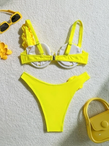 Detail of yellow bikini featuring ruffle shoulder strap and central metal buckle detail