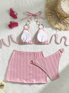 Pink three-piece ribbed bikini set with gold metal rings and matching mini skirt
