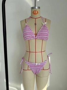 Détail de bikini vichy rose à fronces avec petits nœuds blancs et liens sur les côtés