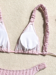 Pink smocked bikini set with ruffled triangle top and matching low-waist bottoms