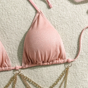 Dettaglio del top bikini rosa scintillante con catene in metallo dorato e coppe a triangolo
