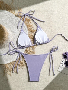 Flat lay of lilac ribbed bikini set with sun hat and sunglasses for summer vacation