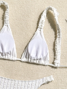 Detail of white bikini set with textured seersucker fabric and ruffled shoulder straps