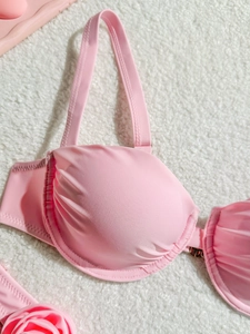 Pink wired push-up bikini top with ruching and 3D flower detail on plush background
