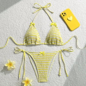 Vue détaillée d'un bikini rayé jaune avec texture froncée et petits nœuds décoratifs