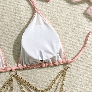 Dettaglio della fodera del bikini rosa con coppe e dettagli della catena dorata