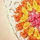 Primer plano de un posavasos de girasol hecho a mano a ganchillo con pétalos de lana vibrantes