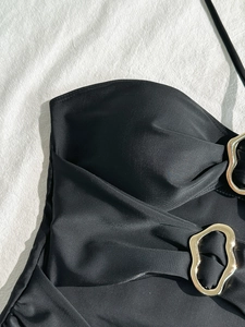 Solid black halter bikini top with elegant pleated texture and golden metal wave buckles