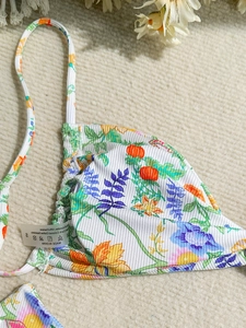 Floral bikini top with pumpkin print and ribbed texture on a soft white background