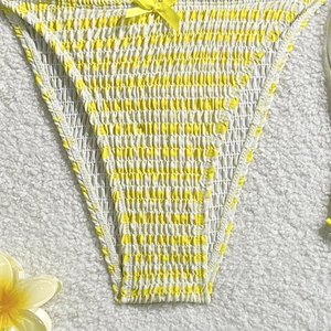 Détail du bas de bikini à rayures jaunes et blanches avec design smocké et nœud