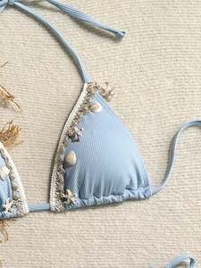 Detail of light blue ribbed bikini top with white lace trim and starfish seashell charms