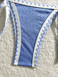Light blue textured bikini bottom with white contrast trim and blue triangle embroidery