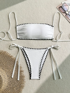 Close-up of white honeycomb texture bikini with black wavy scalloped trim edges