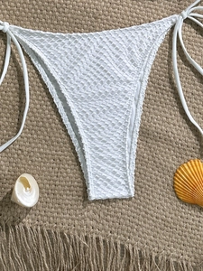 Detailed view of white crochet mesh bikini bottoms with side ties and seashell decor