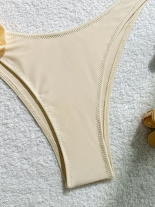 Macro shot of cream bikini bottoms with high-quality zigzag stitching on smooth fabric