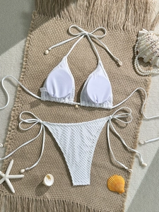 Detailed view of white crochet mesh bikini set with decorative shells and starfish on jute