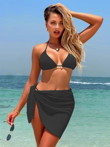 Detail of a black three-piece bikini set with a halter top and matching sarong skirt